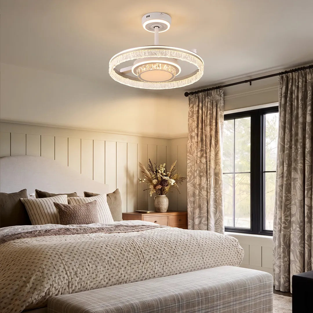 Modern ceiling fan with lights mounted in a stylish bedroom with soft bedding and a glowing circular light frame.