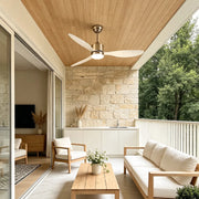 Modern ceiling fans with LED lights installed above a covered patio with cushioned outdoor seating and stone walls.