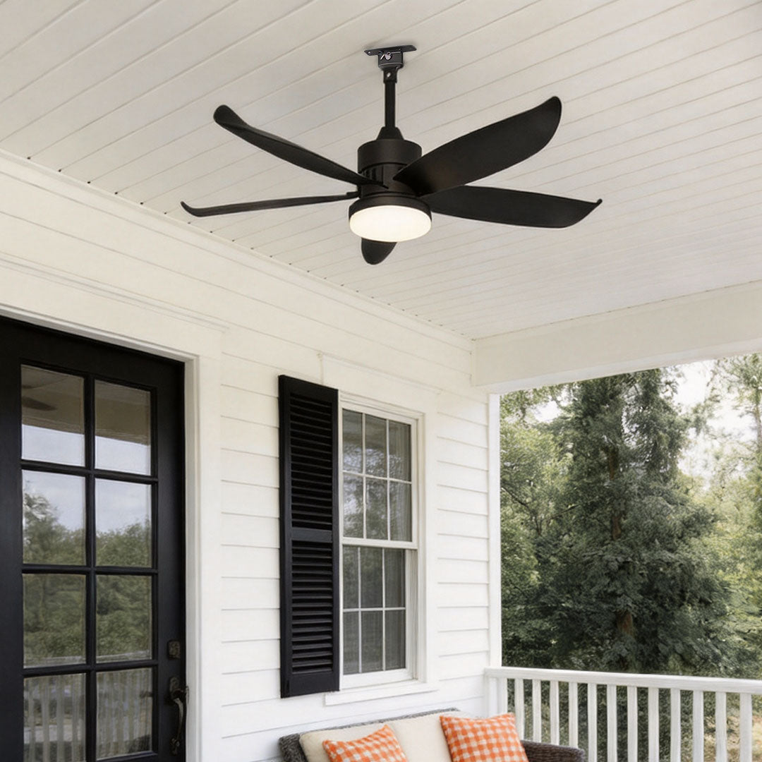 Modern ceiling fans with lighting installed on a white covered porch above a cozy outdoor seating area.
