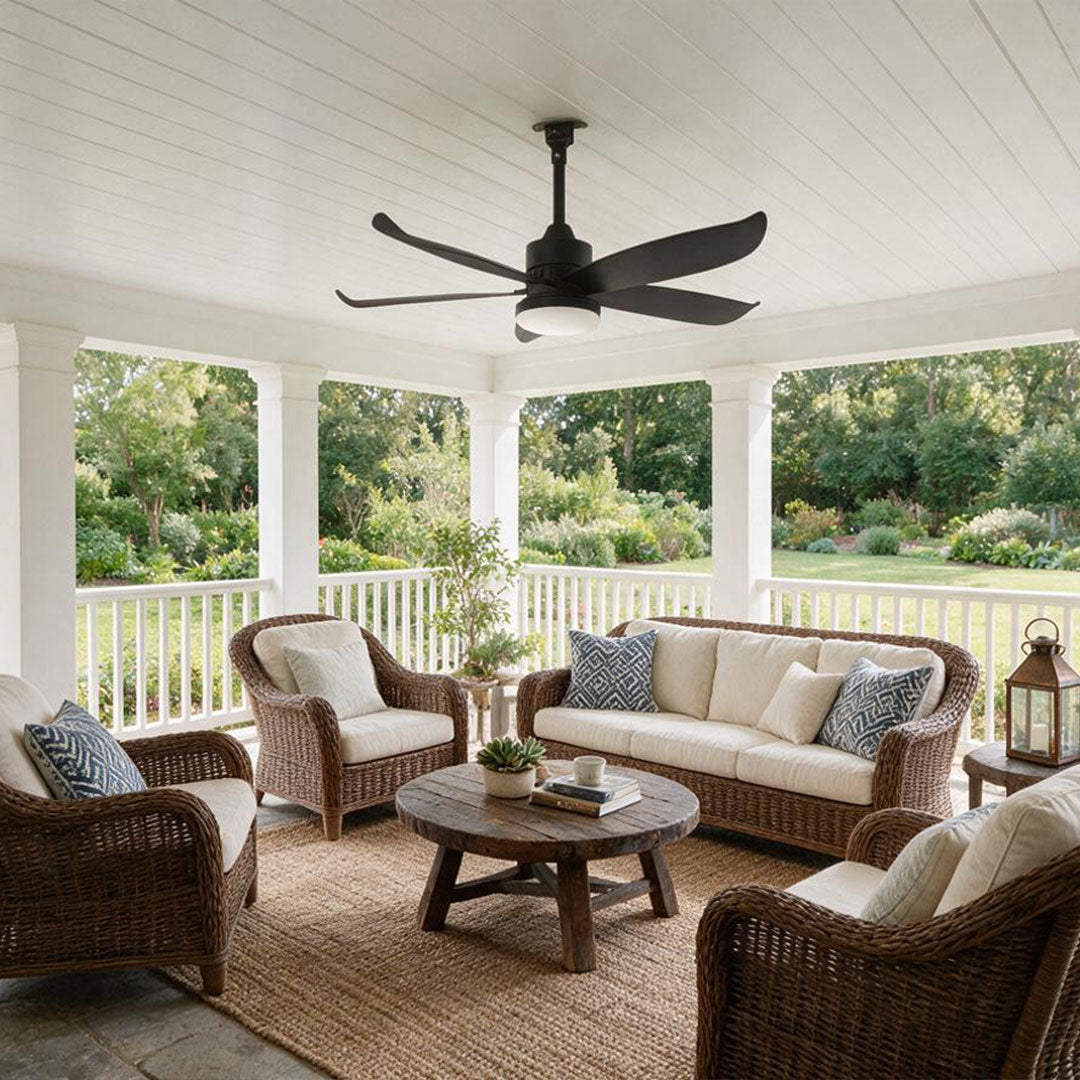 Modern ceiling fans with lighting mounted on a spacious covered porch with wicker chairs and cushioned sofas.