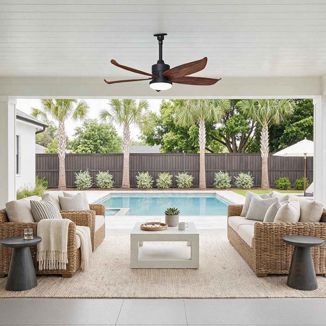 Modern ceiling fans with lighting above a bright covered patio with woven seating and a pool view.