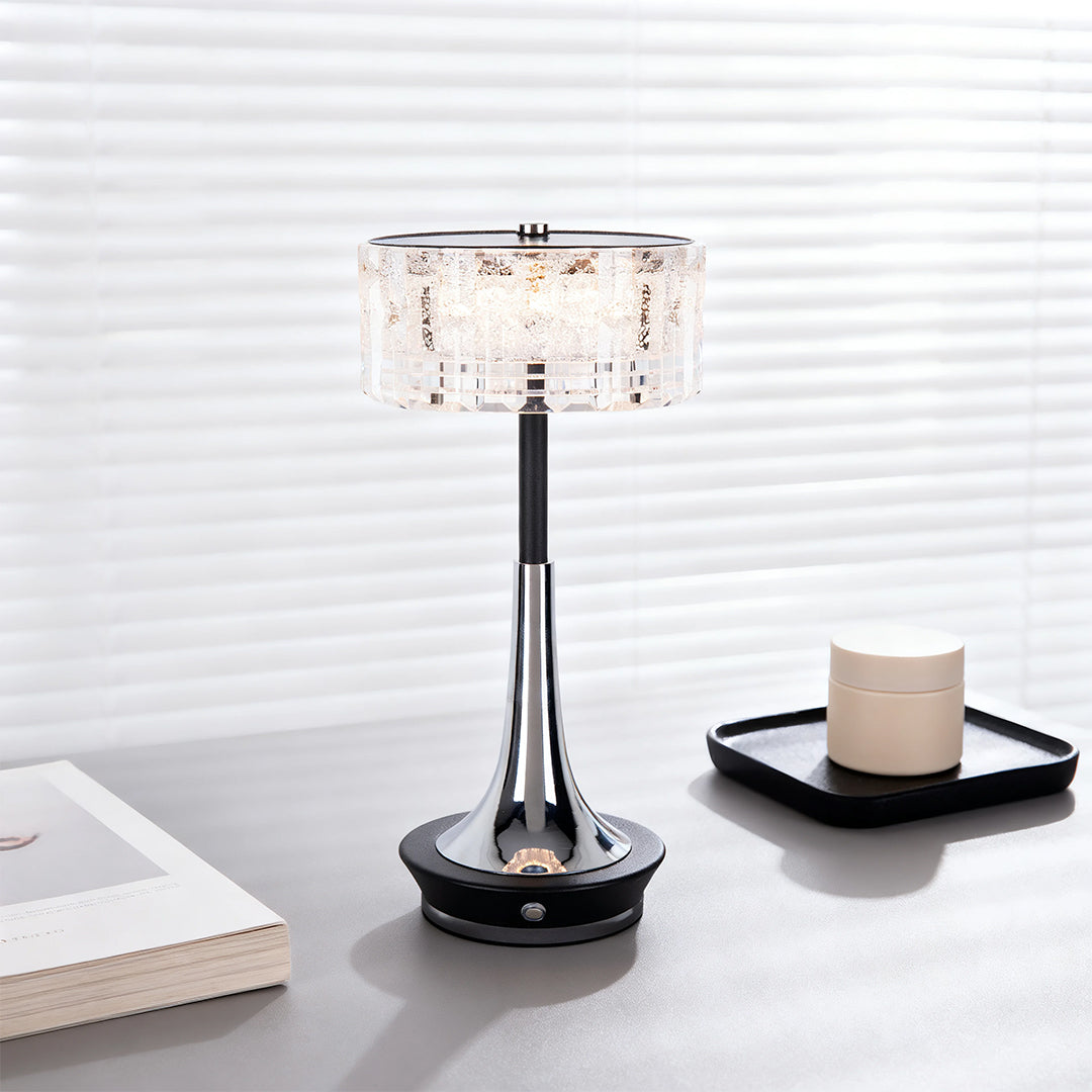 Modern chrome cordless mushroom table lamp with a shimmering crystal shade on a grey desk with a minimalist tray. 