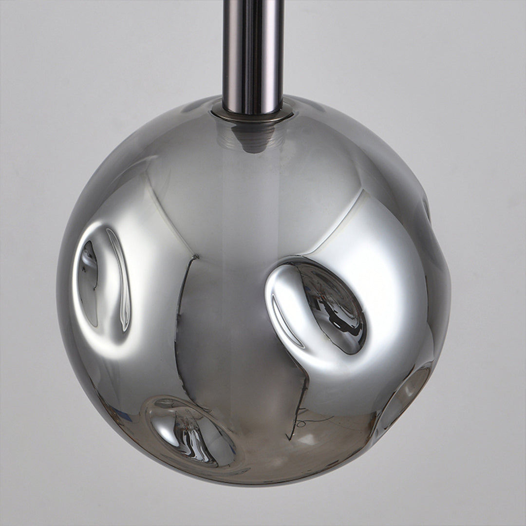 Modern drum pendant lights featuring chrome spherical design with circular cutout details