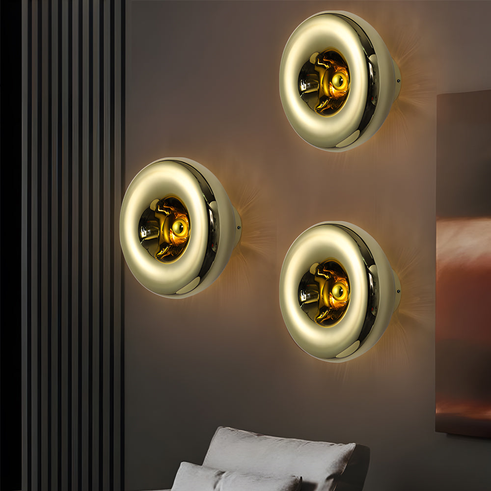 Modern chrome wall sconce with a golden interior, providing soft illumination in a living room.