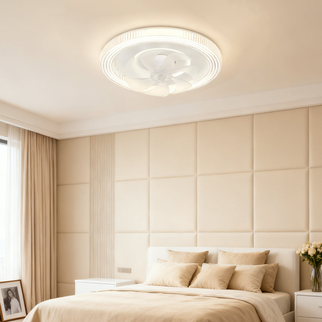 Modern circular ceiling fan with light fixture installed in a large bedroom with a beige upholstered headboard and soft neutral decor. 