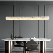 Modern copper metal pendant light with a marble accent, providing stylish illumination in a minimalist kitchen