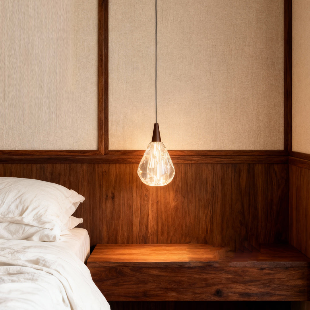 Modern crystal pendant lighting illuminating bedroom with warm glow above wooden headboard and contemporary wood paneling