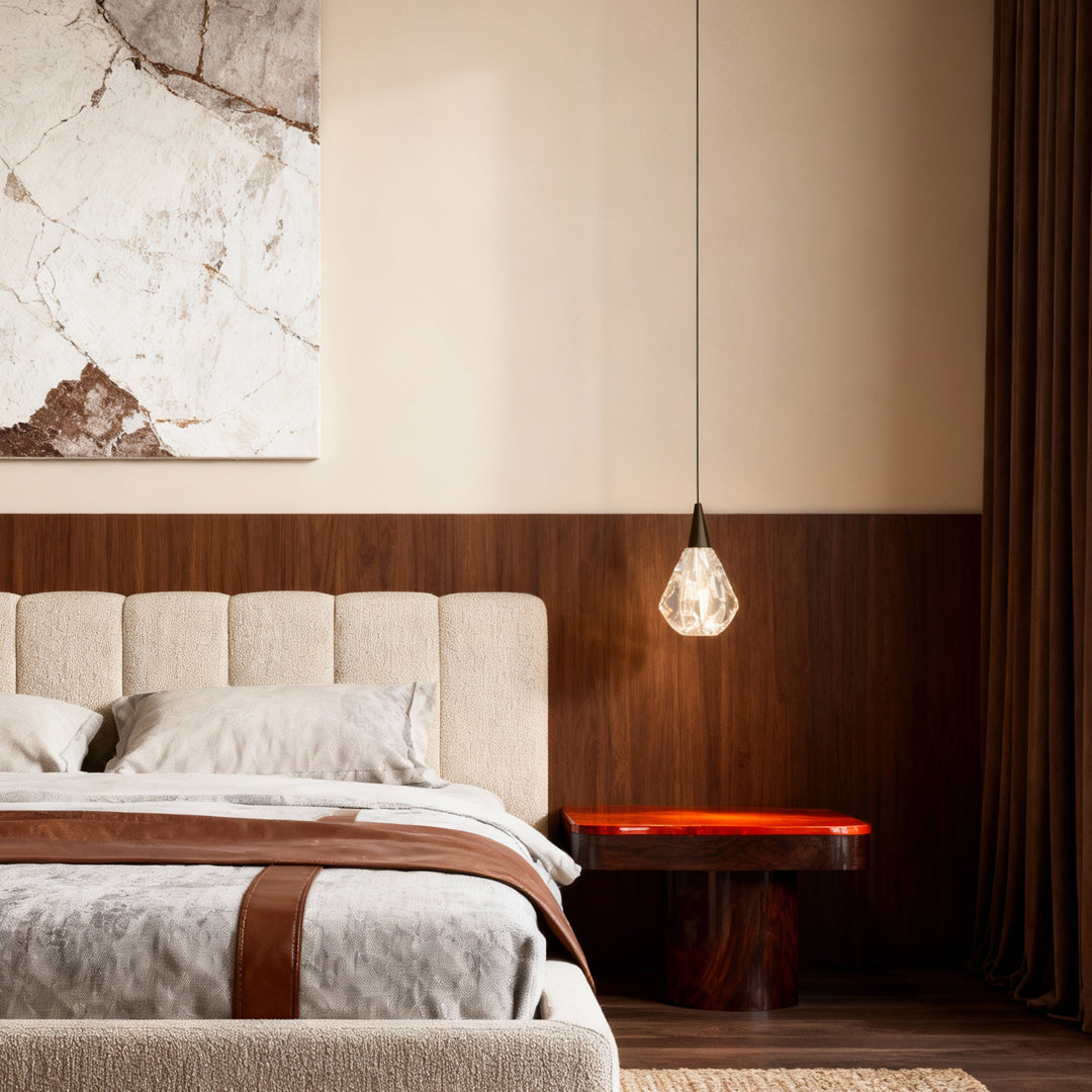 Modern crystal pendant lighting suspended beside tufted headboard in elegant bedroom with wood paneling and marble artwork