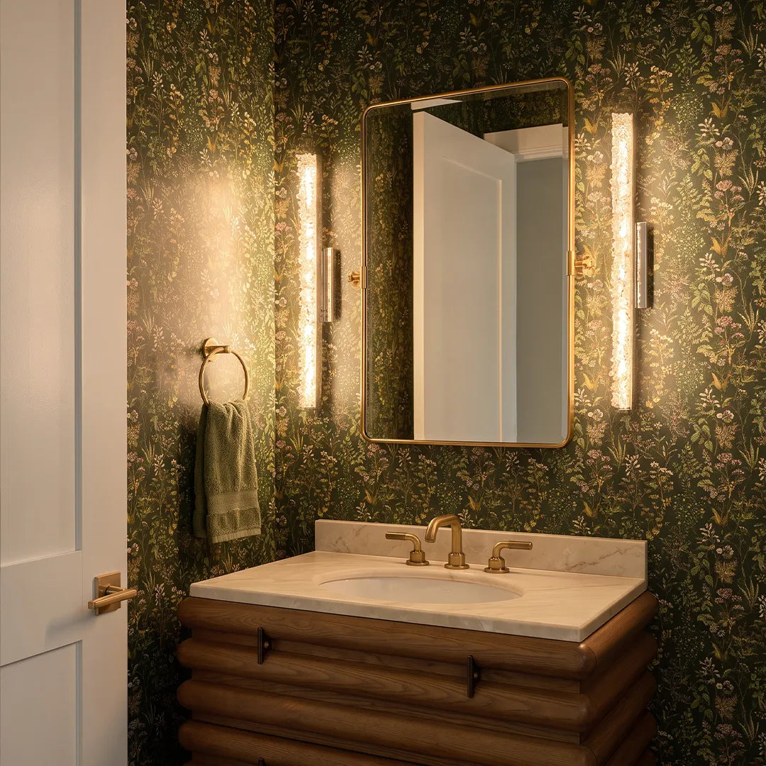 Modern crystal wall lights installed on both sides of a bathroom mirror over a single vanity.