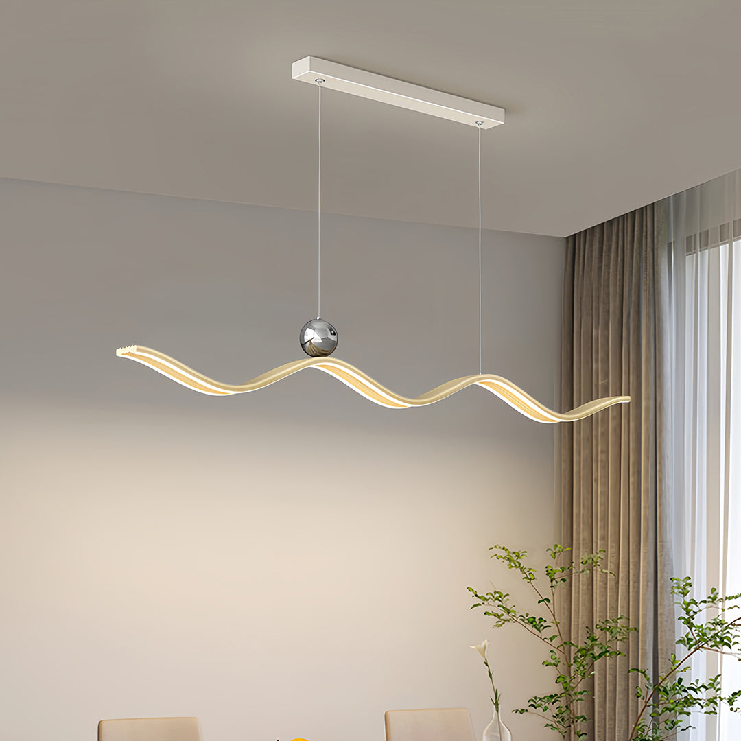 Modern curved linear LED pendant light with a polished chrome canopy, suspended over a dining area, providing bright, continuous task lighting.