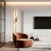 Elegant modern curved wall sconce with warm light, enhancing the ambiance of contemporary living rooms or bedrooms.