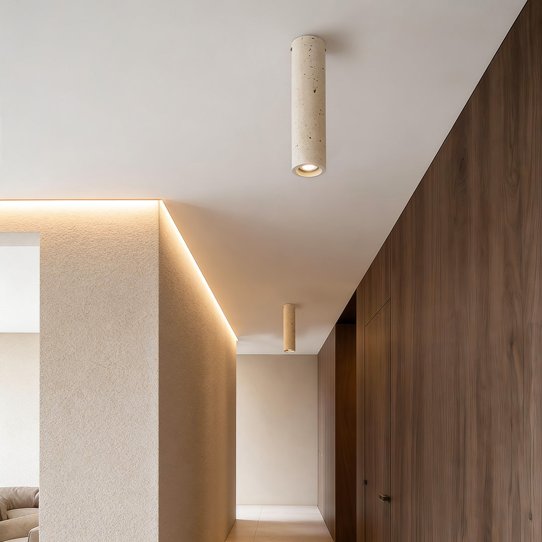 Modern cylinder downlight suspended from a ceiling, providing warm illumination in a hallway with wooden accents.