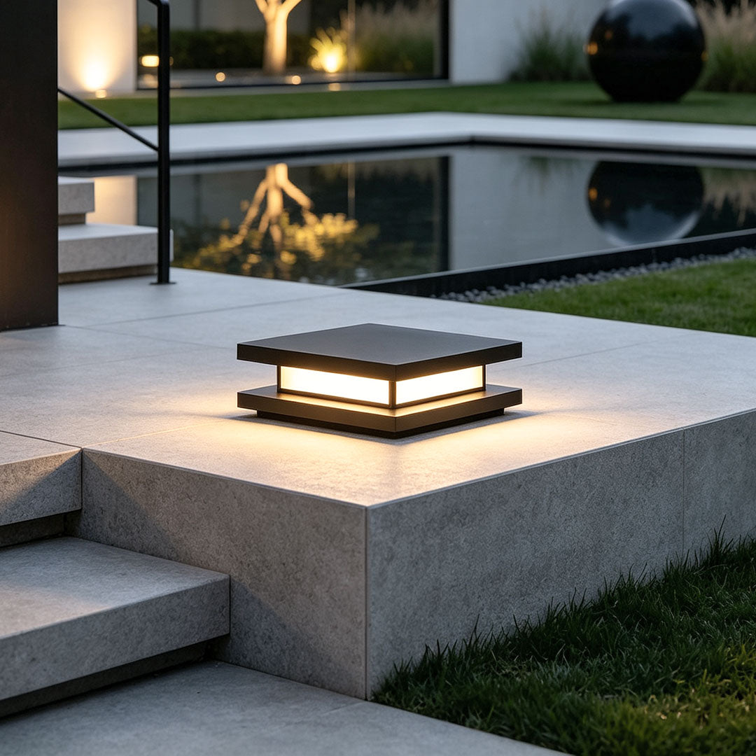 Modern decorative garden lights illuminating contemporary backyard pool and outdoor patio at night.