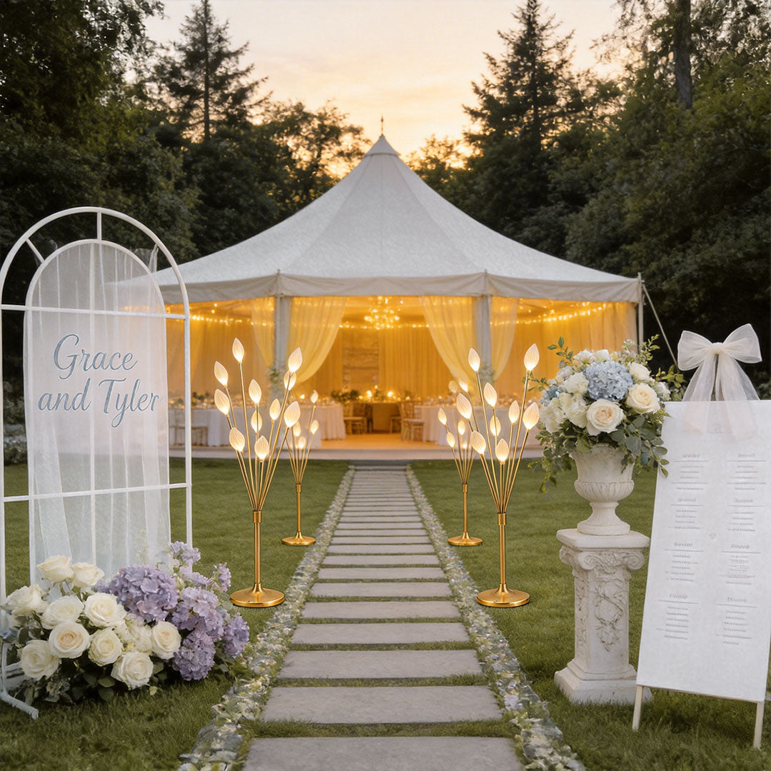 Modern decorator floor lamps along a garden wedding aisle leading to a large white party tent.
