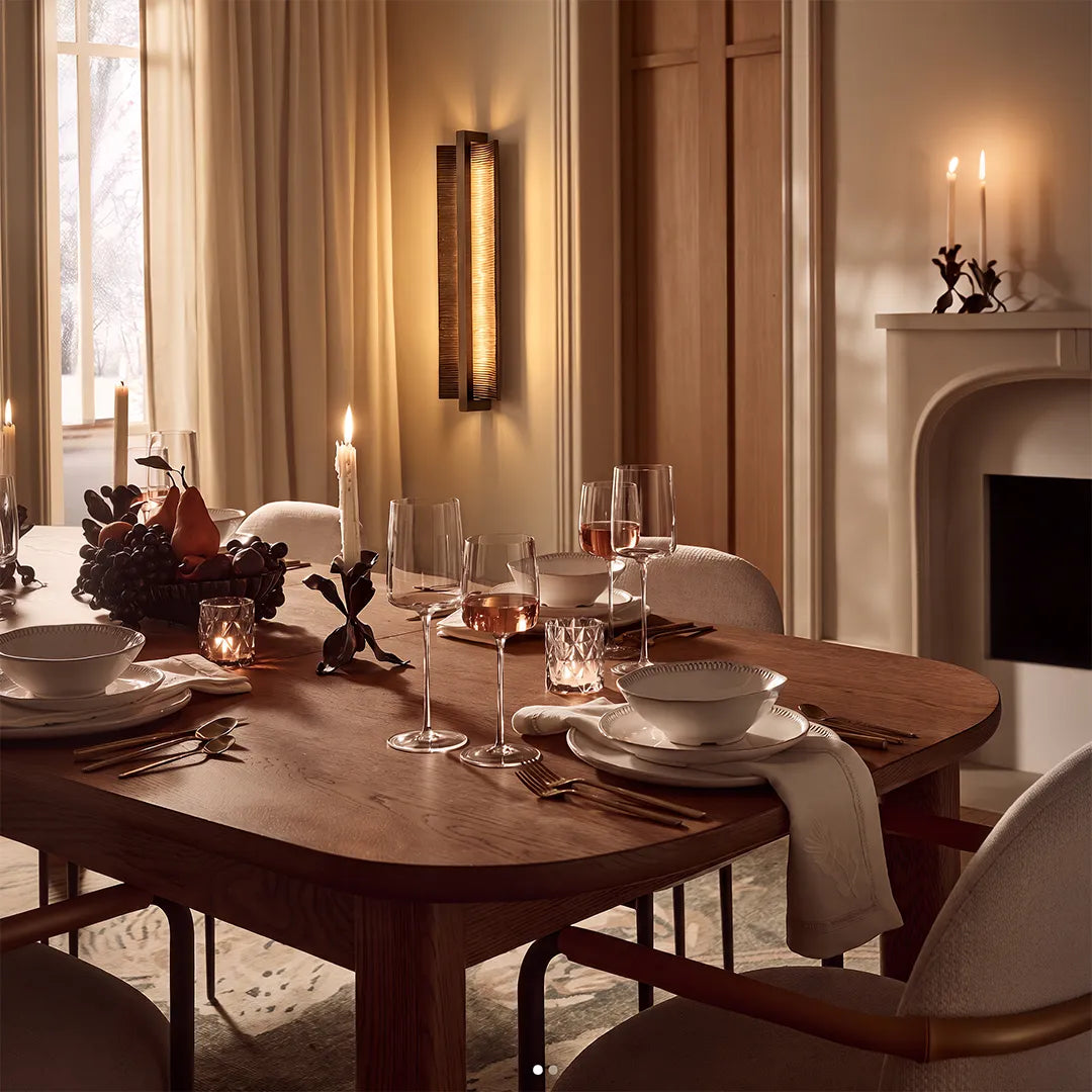 Modern dining room with vertical wall sconce wooden table and warm ambient lighting