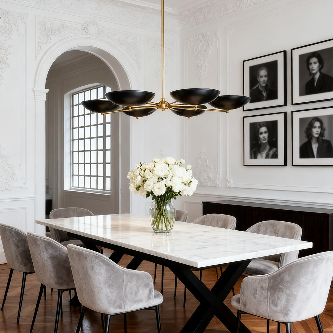 Modern disc black and gold chandeliers with five lights, suspended over a marble-top dining table in a formal room with historical details.