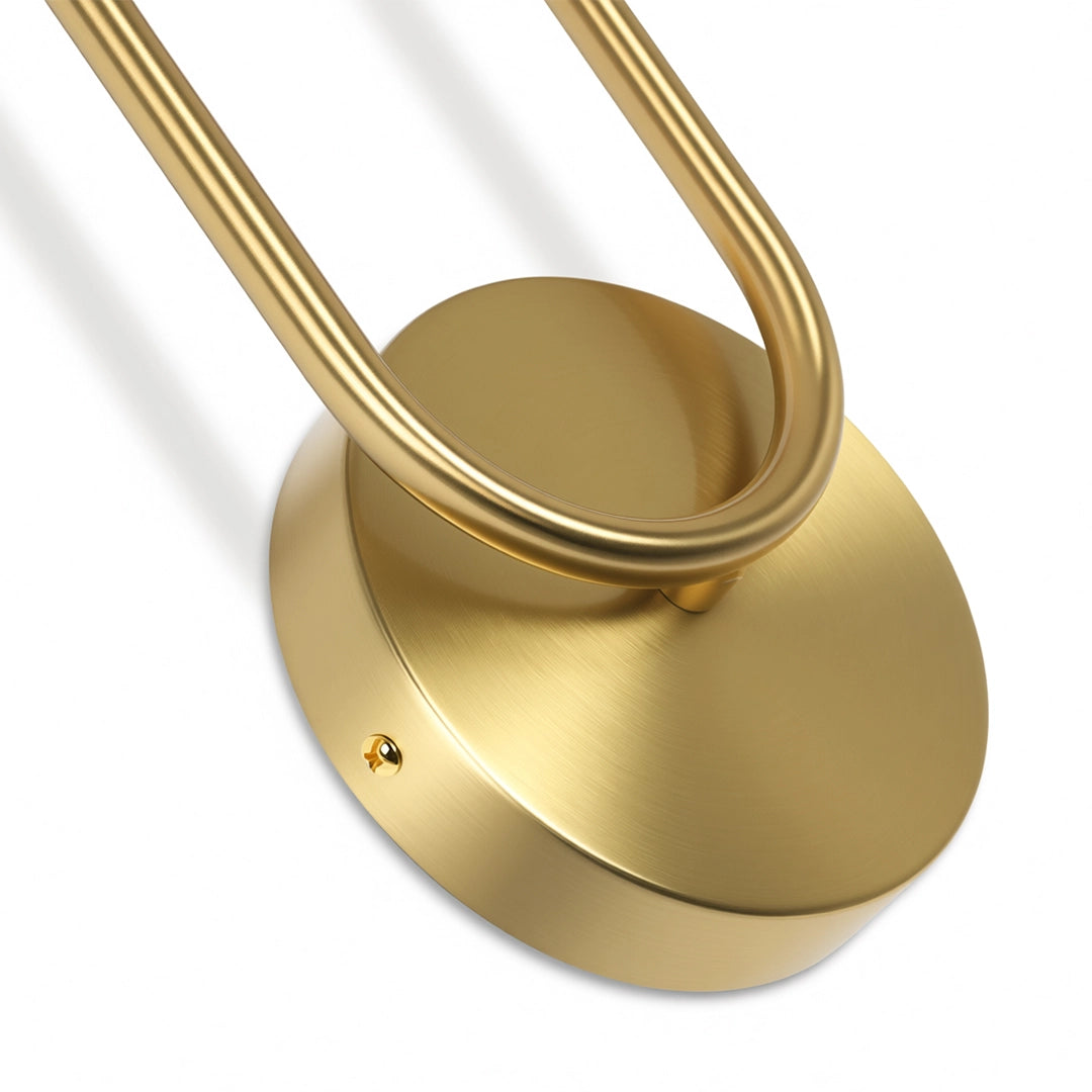 Close-up of the round gold backplate and curved arm detail of a modern double heads wall sconce.