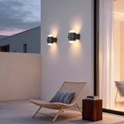 Modern double heads wall sconce illuminating a contemporary house entrance with warm directional light.