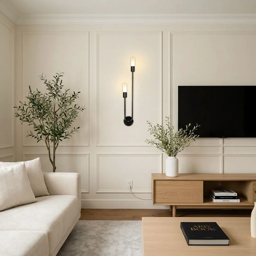 Modern double heads wall sconce beside a media console, designed with two slim light heads and a minimalist black wall base.