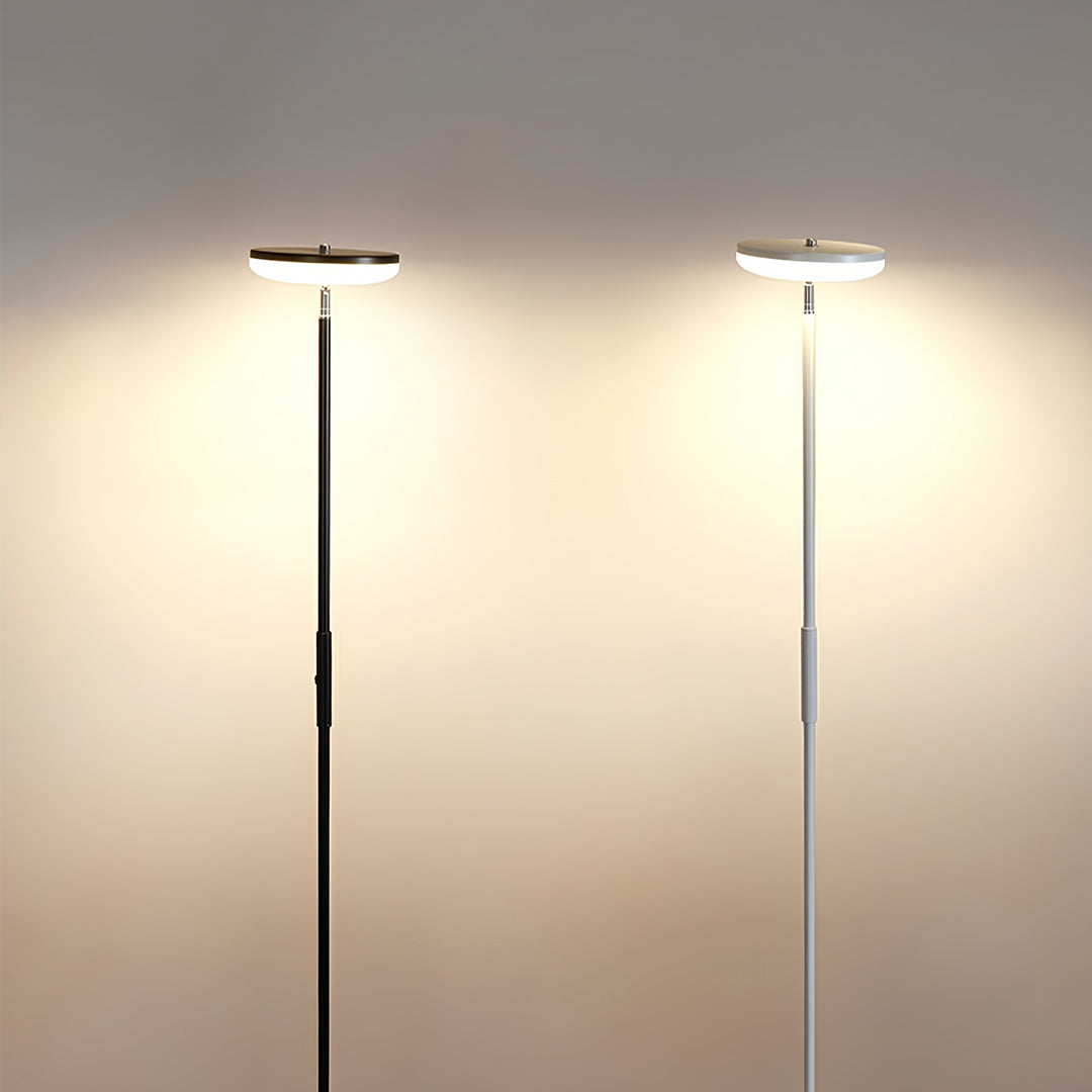Modern downlight floor lamp with sleek black pole and circular LED top providing ambient ceiling illumination