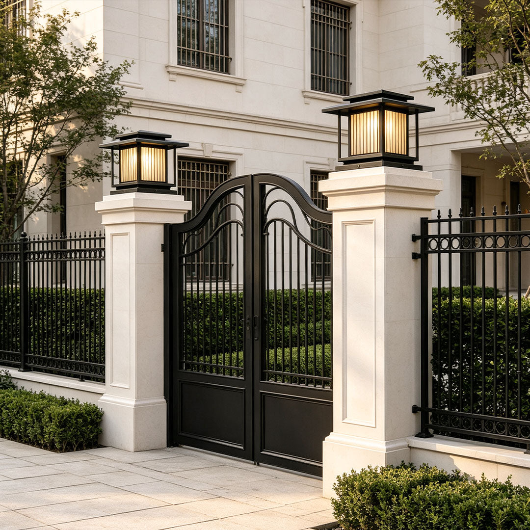 Modern residential driveway featuring stylish driveway pillar solar lights beside black entry gate.