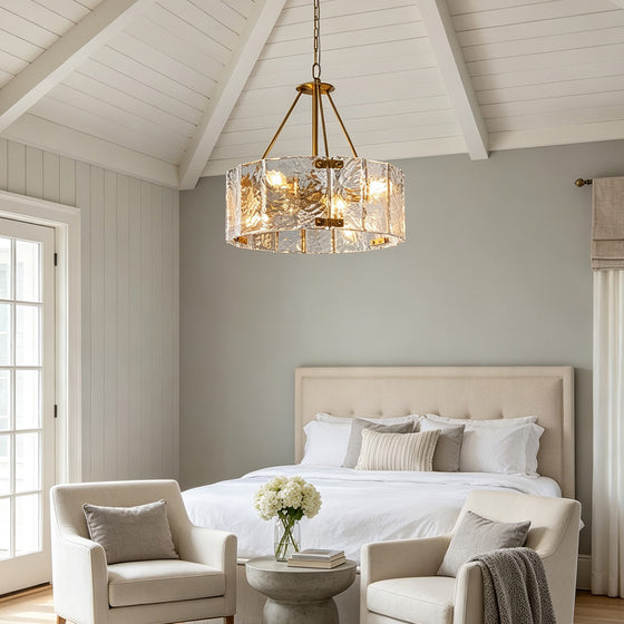 Modern drum chandelier hanging above a serene bedroom with vaulted ceiling and soft neutral decor.