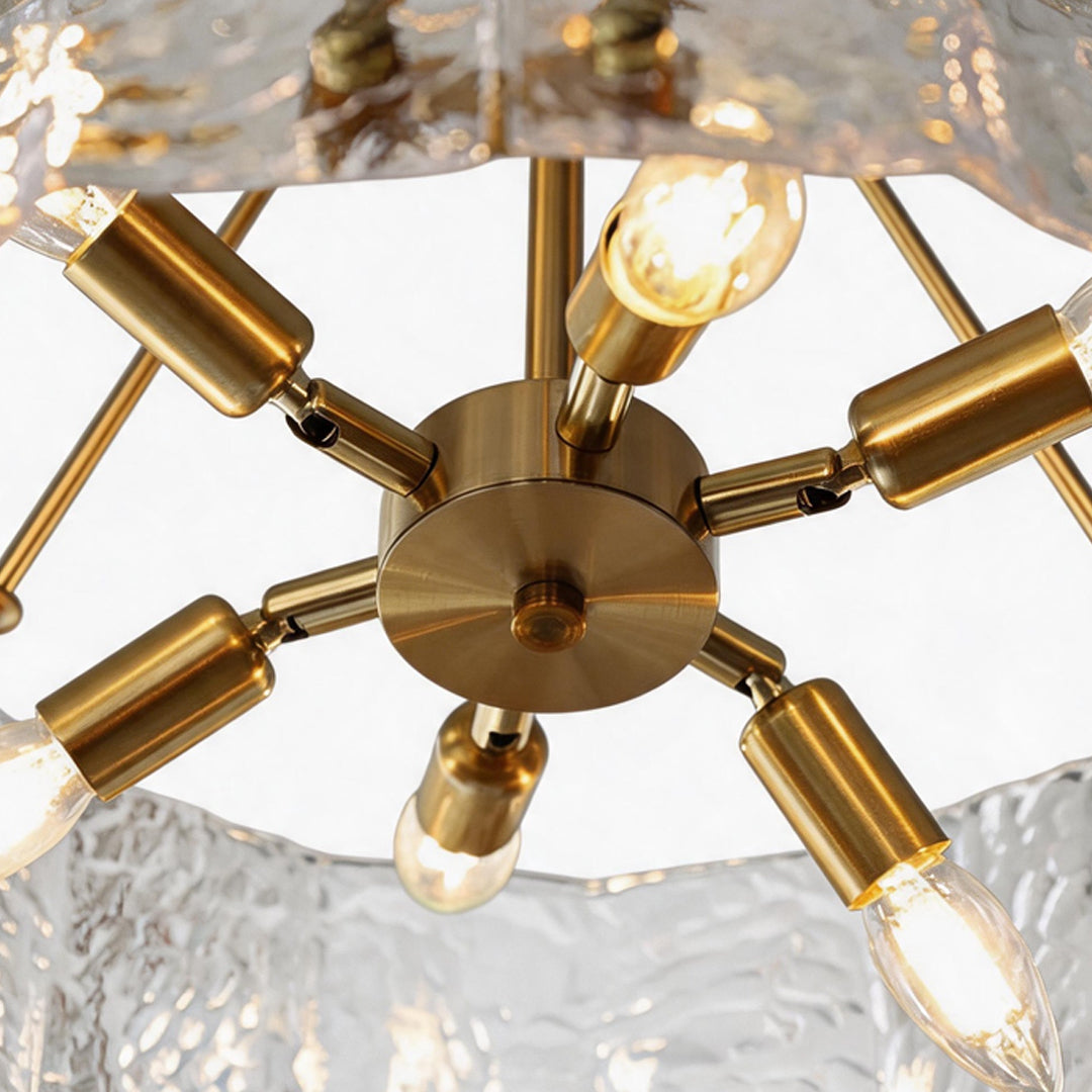 Modern drum chandelier close-up showing brass bulb holders and textured glass drum frame.