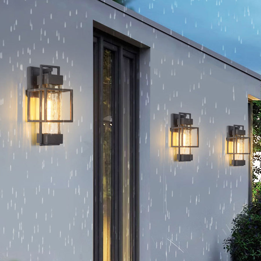 Modern black wall lanterns illuminating contemporary home exterior during evening rainfall