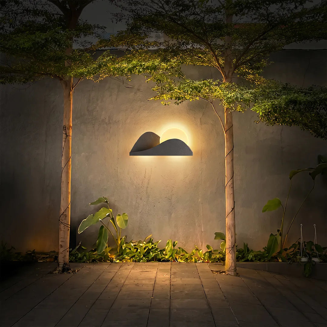 Modern exterior wall lighting creating warm illumination across a minimalist garden courtyard at night.