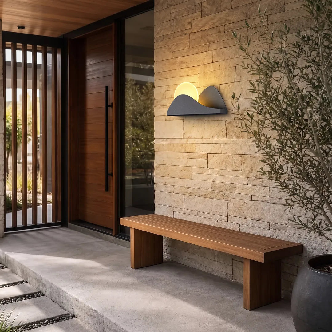 Modern exterior wall lighting mounted on a textured stone wall beside a minimalist entryway.