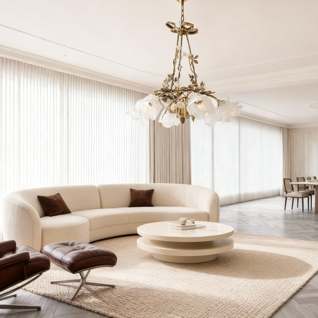 Modern flower chandelier suspended above circular coffee table in contemporary living space with cream furnishings