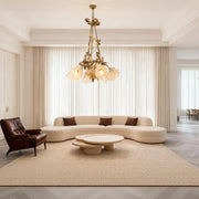 Modern flower chandelier illuminating minimalist living room with curved sofa and neutral color palette creating elegance