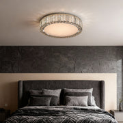 Modern flush mount ceiling light in a bedroom with large windows, adding a touch of elegance to the space.