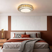 Modern flush mount light in a modern bedroom with a minimalist decor, offering a stylish focal point.