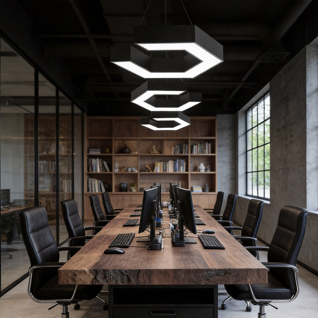 Modern forms chandeliers illuminating a large conference room, featuring geometric LED shapes that enhance a sleek industrial workspace.