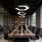 Modern forms chandeliers illuminating a large conference room, featuring geometric LED shapes that enhance a sleek industrial workspace.