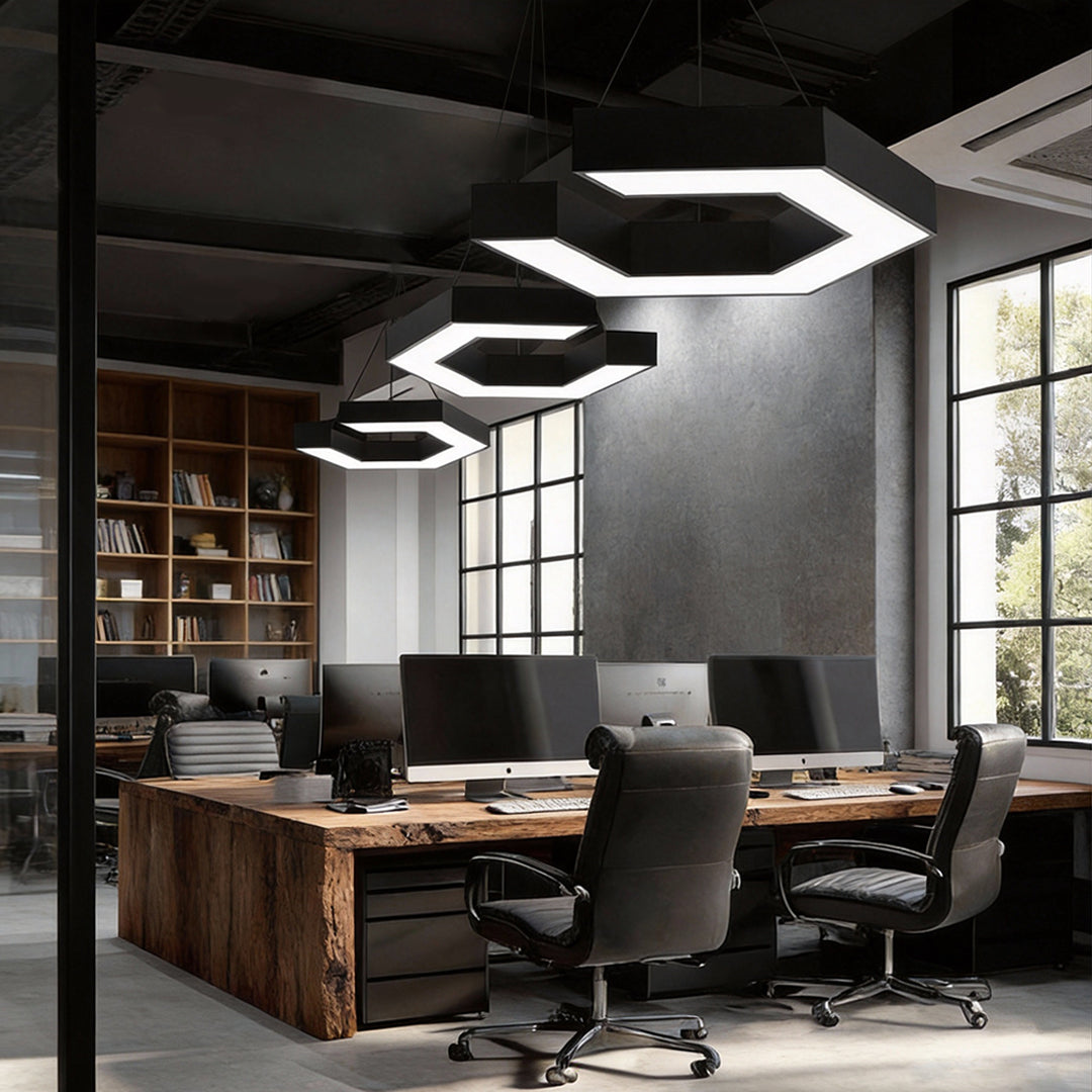 Modern forms chandeliers lighting a creative office workspace, combining angular LED frames with a modern industrial ceiling design.