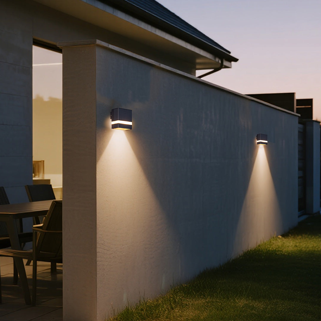 Modern garden wall light brightening blue contemporary home exterior at twilight
