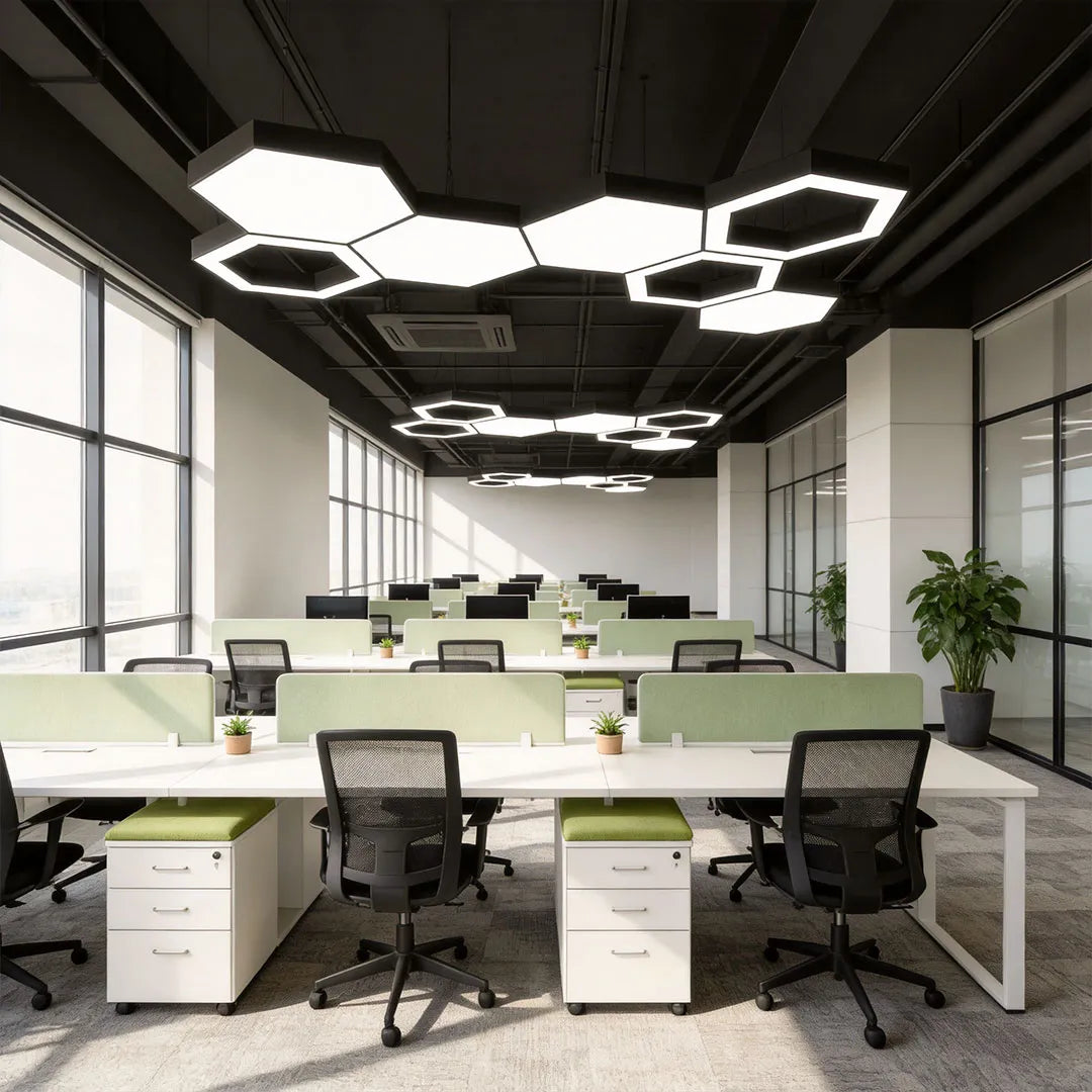 Modern geometric chandelier illuminating a large open-plan office with shared desks and task chairs.