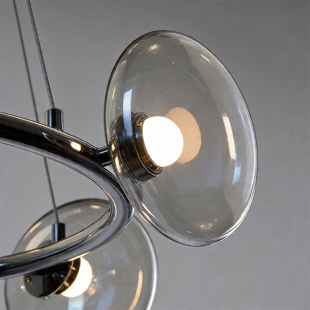 Close-up detail of modern glam chandelier with glass disc shades and metallic frame structure.