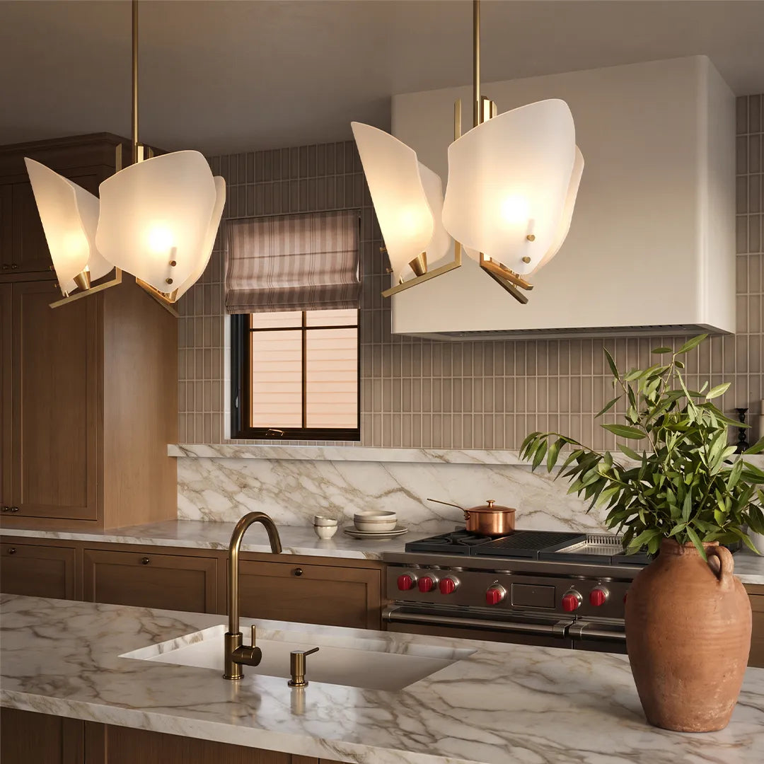 Modern glass chandelier illuminating a stylish kitchen with a marble backsplash and warm wood finishes.