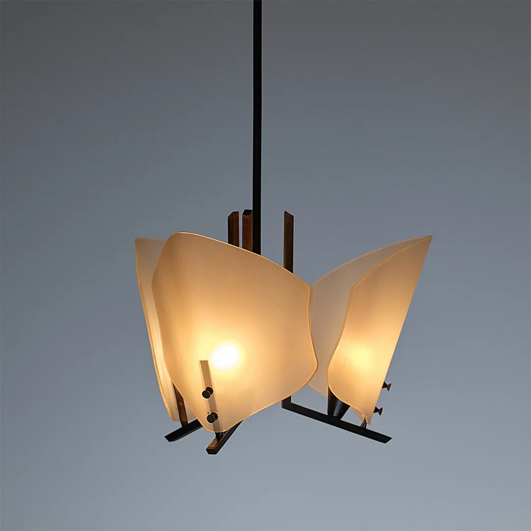 Modern glass chandelier product detail showing sculptural frosted glass shades and glowing bulbs.