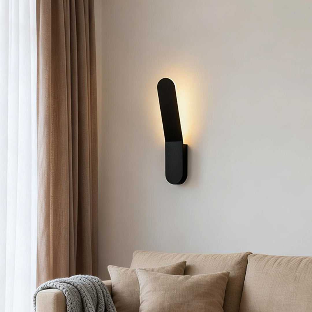 Modern glass pendant chandelier providing soft illumination beside a minimalist bed.