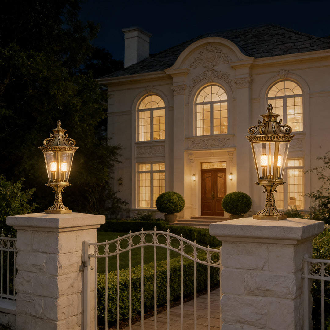 Modern glass pillar lights illuminating the entrance of a grand house, offering soft and inviting outdoor lighting.