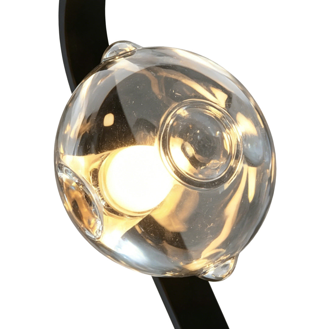 Modern black frame wall sconce with clear glass shade design.
