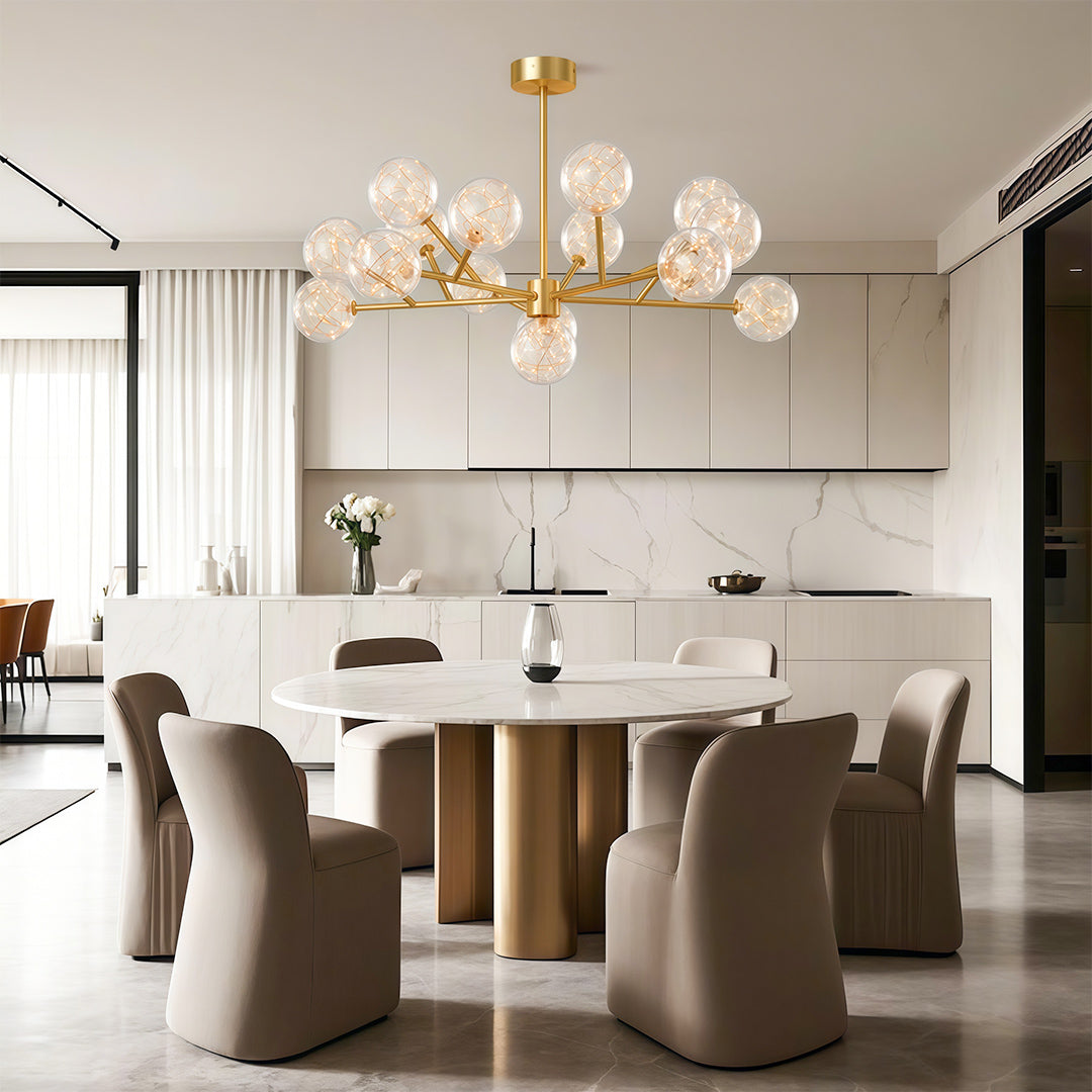 Modern glass globe chandelier illuminating bright dining space with brown chairs and artwork