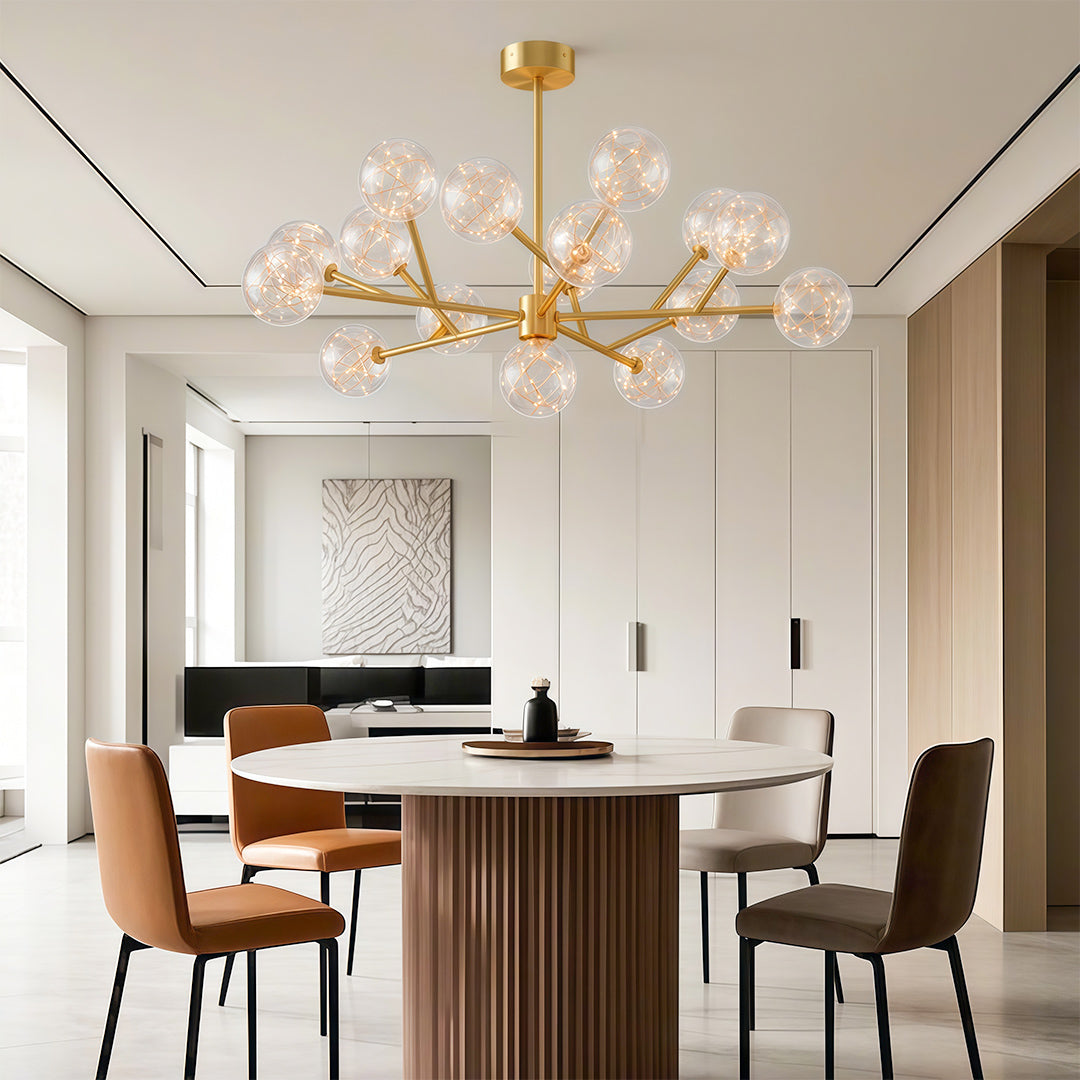Modern luxury chandeliers above contemporary dining table with rust-colored upholstered chairs