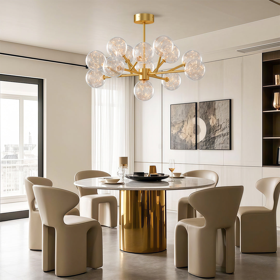 Modern glass globe chandelier creating focal point in elegant dining space with brass table