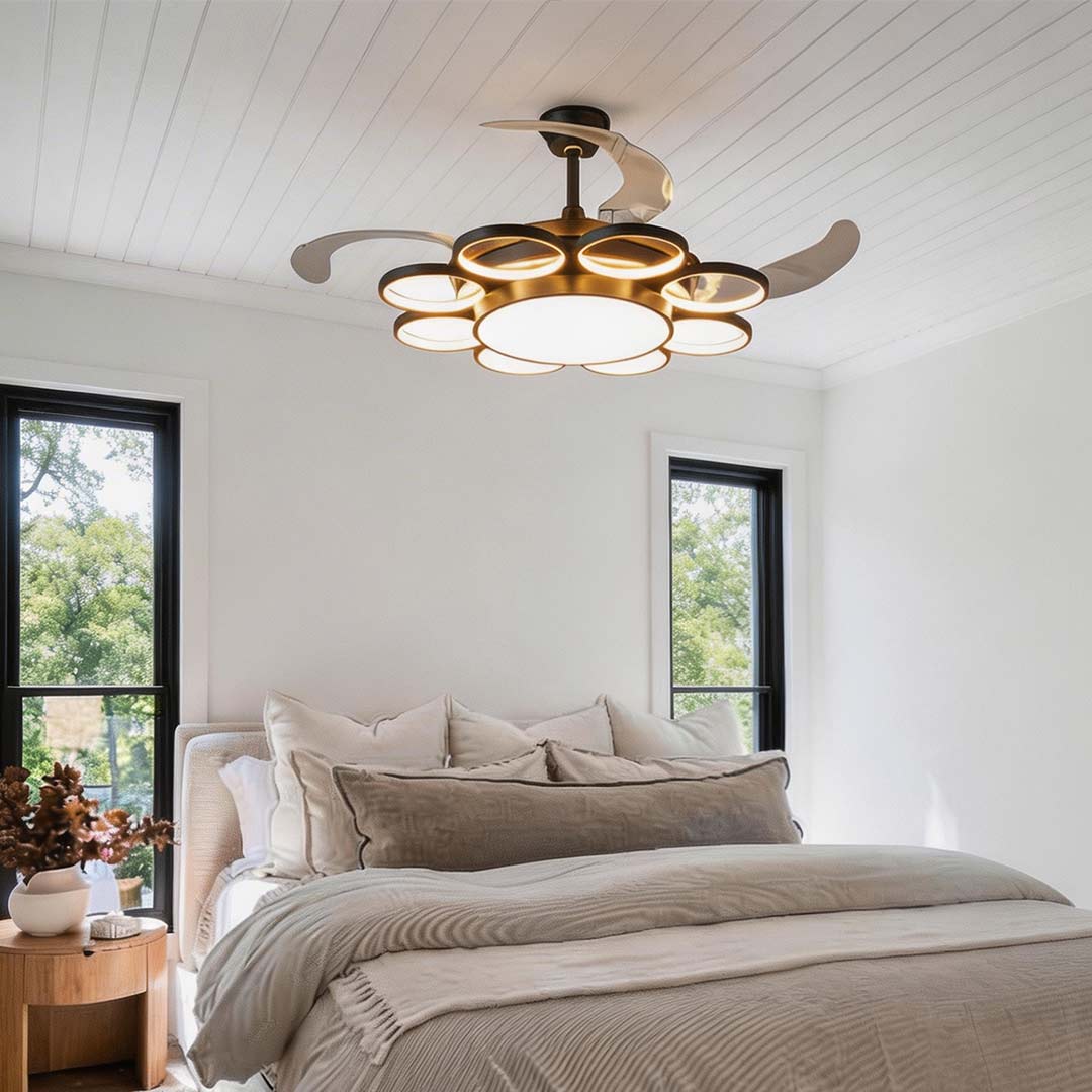 Modern gold ceiling fan with light, enhancing a contemporary bedroom with large windows.