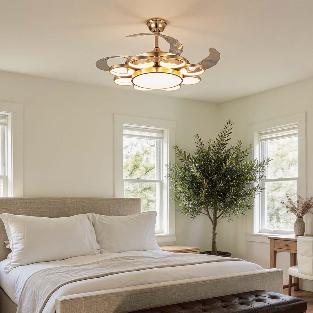 Modern gold ceiling fan with light, illuminating a cozy bedroom with natural decor.